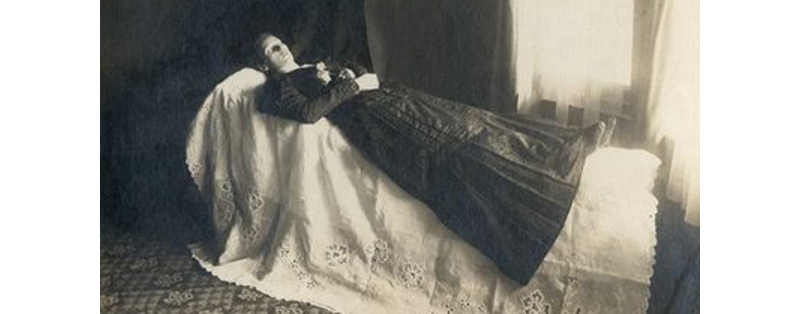 A post-mortem photo of a corpse on display, possibly for a wake, late Victorian.